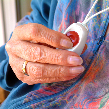 Bild von Frauenhand mit Notruftaster